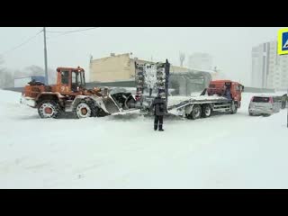 Погрузчик вытаскивает КамАЗ из снега на Сахалине